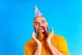 happy man with colorful beard wear horn on head in blue studio background