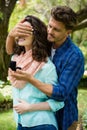 Happy man covering woman eyes while gifting her ring Royalty Free Stock Photo