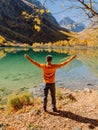 Happy man at crystal lake in autumnal mountains. Mountain lake and hiker Royalty Free Stock Photo