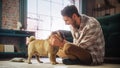 Happy Man Cuddles His Adorable Little Pug, Gives it Snacks at Home. Handsome Man Plays with His Dog