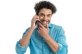 happy man with curly hair talking on the phone, holding hand to chin and thinking Royalty Free Stock Photo