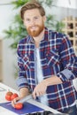 Happy man cutting tomatoes on cutting board