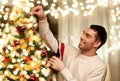 Happy man decorating christmas tree at home Royalty Free Stock Photo