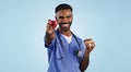 Happy man, doctor and apple with donut for diet or healthy eating by a blue studio background. Portrait of male person Royalty Free Stock Photo