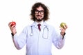 Happy man doctor smiling while holding red apple and green apple Royalty Free Stock Photo