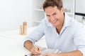 Happy man doing a crossword sitting at a table Royalty Free Stock Photo