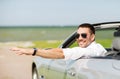 Happy man driving cabriolet car and waving hand Royalty Free Stock Photo