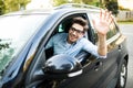 Happy man driving car and waving hand Royalty Free Stock Photo