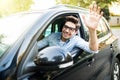 Happy man driving car and waving hand Royalty Free Stock Photo