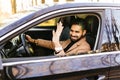 Happy man driving car and waving hand Royalty Free Stock Photo