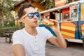 Man eats a hamburger near an outdoor foodtruck. Streetfood and junk food concept