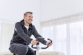 Happy man exercising on a spin bike at home Royalty Free Stock Photo