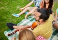 Happy man with friends playing guitar at camping Royalty Free Stock Photo