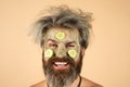 Happy Man with funny facial mask with Cucumber having fun. Procedure for applying mask from clay to face of funny man