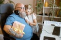 Happy man with gift box embraces blonde little girl holding greeting card in home office Royalty Free Stock Photo