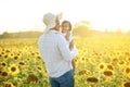 Happy man and girl in a field of sunflowers at sunset. Royalty Free Stock Photo