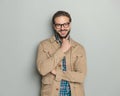 happy man with glasses touching beard and smiling with folded arms Royalty Free Stock Photo