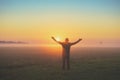 Happy man stands in the field at sunrise Royalty Free Stock Photo