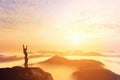 Happy man with hands up on the top of the world above clouds. Bright future