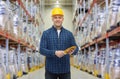 Happy man in hardhat with gloves over warehouse