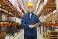 Happy man in hardhat with gloves over warehouse