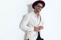 happy man with hat and sunglasses unbuttoning white jacket suit Royalty Free Stock Photo