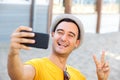 Happy man with hat taking selfie with smart phone at the beach Royalty Free Stock Photo