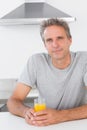 Happy man having glass of orange juice in kitchen Royalty Free Stock Photo