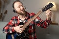 Happy man in headphones with a guitar gives an online lesson to the camera.