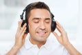 Happy man in headphones listening to music at home Royalty Free Stock Photo