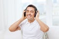 Happy man in headphones listening to music at home Royalty Free Stock Photo