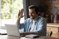 Happy man in headphones using laptop, making video call Royalty Free Stock Photo