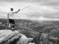 Happy man hiker holding medicine crutch above head, injured knee fixed in knee brace feature Royalty Free Stock Photo