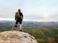 Happy man hiker holding medicine crutch above head, injured knee fixed in knee brace feature