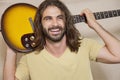 Happy man holding guitar on back of his shoulders