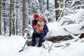 Happy man holding lovely dog in his hands in snowy forest. Smiling boy hugging adorable puppy in winter wood. Pet lover Royalty Free Stock Photo