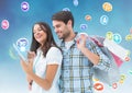 Happy man holding shopping bags and woman using digital tablet with various icons in background Royalty Free Stock Photo