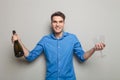 Happy man holding two glasses and a bottle of champagne. Royalty Free Stock Photo