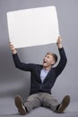 Happy man holding white blank signboard.