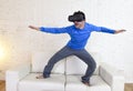 Happy man at home living room sofa couch excited using 3d goggles virtual reality surfing