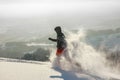 Happy Man with hood running in deep powder snow with snowshoes. Snow is spraying and splashing. Royalty Free Stock Photo
