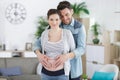 happy man hugging pregnant wife standing at home Royalty Free Stock Photo