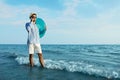 Happy man with inflatable ring talking by mobile phone near sea on beach. Business trip Royalty Free Stock Photo