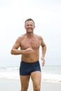 Happy man jogging on beach. Royalty Free Stock Photo