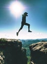 Happy Man jumping above cracked sandstone cliff. Travel style