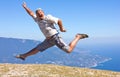 Happy man jumping over mountains, sky and sea Royalty Free Stock Photo