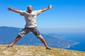 Happy man jumping over mountains, sky and sea Royalty Free Stock Photo