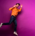 Happy man jumps against a purple background