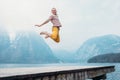 Happy man jumps on wooden pier at the mountain lake Royalty Free Stock Photo