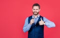 Happy man karaoke singer vocalist with mic show thumbs up red background copy space, satisfied